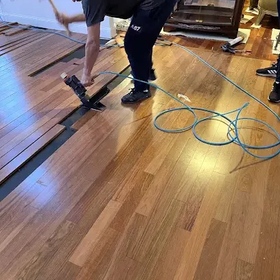 Air movers and hoses drying a wood floor after a storm leak inside a home