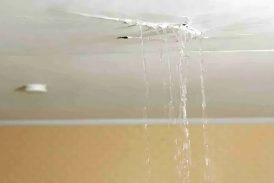 Water pouring through a split in a living room ceiling